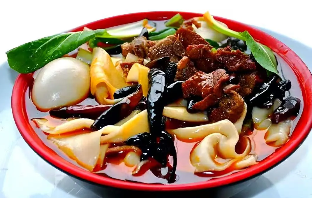 Spicy wide hand-cut noodle stew with braised beef, wood ear mushrooms and greens at Noodles + BBQ, a Chinese Restaurant in Los Angeles Spicy wide hand-cut noodle stew with braised beef, wood ear mushrooms and greens at Noodles + BBQ, a Chinese Restaurant in Los Angeles